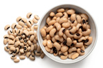 bowl of cooked black eyed peas by pile of uncooked black eyed peas