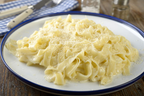 fettuccini alfredo on a white blue-rimmed plate