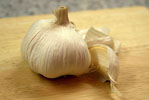 garlic bulb and garlic clove on a wooden board