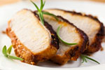 three slices of roasted pork tenderloin  with rosemary sprigs