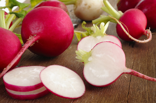 whole raw radishes, half radishes and radish slices