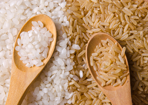 white rice and brown rice and in wooden spoons