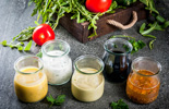 five varieties of salad dressing in cruets