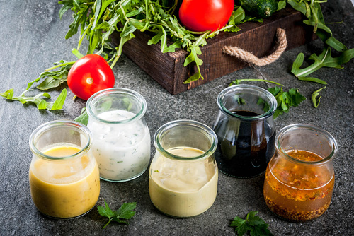 five varieties of salad dressing in cruets