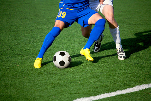 two association football players and one soccer ball