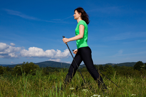 nordic walker walking with poles in a field